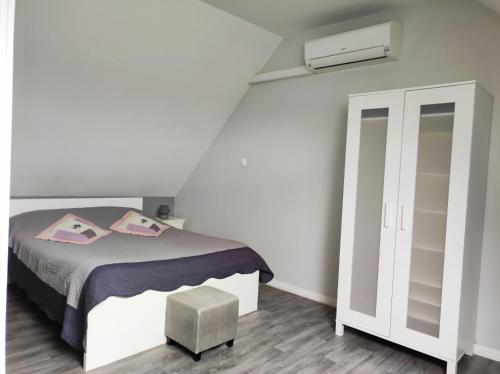 a white bedroom with a bed and a closet at Le Vallon de Paray in Paray-le-Monial