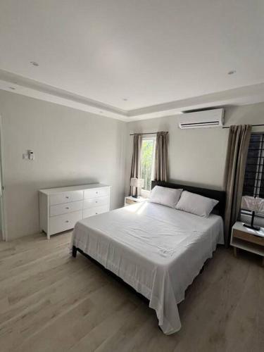 a white bedroom with a bed and a window at Solaris 2: Peaceful Condo close to Tourist Spots in Corinthe