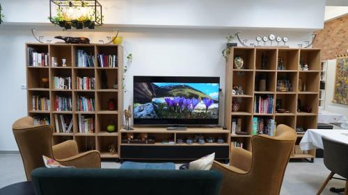 a living room with a tv and book shelves at Stara Plebania in Ponice