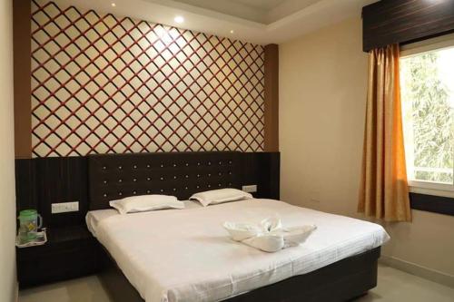 een slaapkamer met een bed met twee witte kommen erop bij Omm Palace in Puri