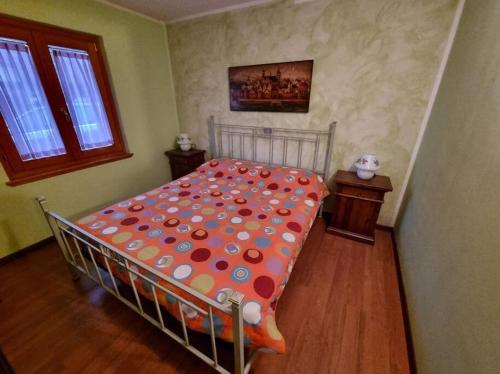 een slaapkamer met een bed met een polka dot-deken bij Appartamento Aprica (SO) in San Pietro