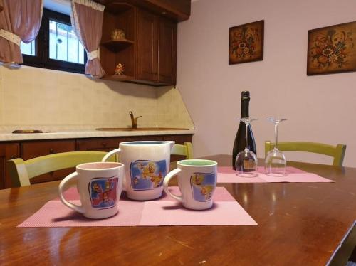 drie koffiemokken op een tafel in een keuken bij Appartamento Aprica (SO) in San Pietro