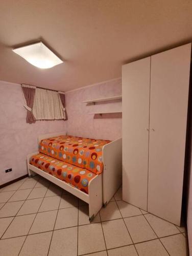 een kleine kamer met een bed in een kamer bij Appartamento Aprica (SO) in San Pietro