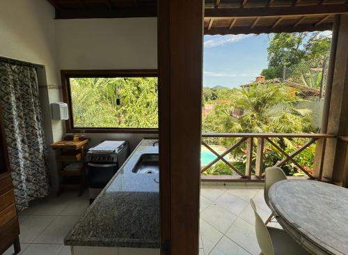a kitchen with a view of a balcony at Casa próxima ao mar e montanha in Ilhabela