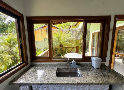 a kitchen with a sink and a window at Casa próxima ao mar e montanha in Ilhabela