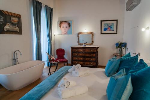 a bathroom with a bath tub and a bed with towels at Como Icon Centro Apartment By Icon7 Luxury in Como