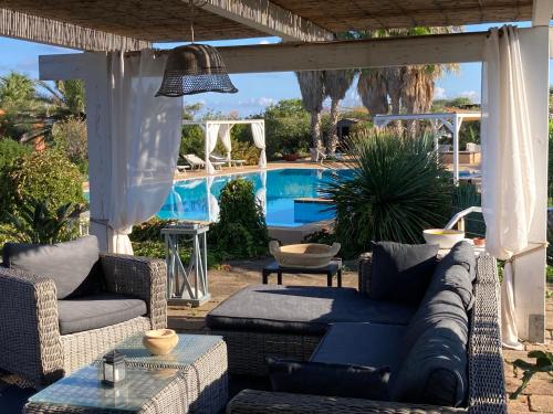 eine Terrasse mit Sofas und einem Pool in der Unterkunft Le Lanterne Resort in Pantelleria