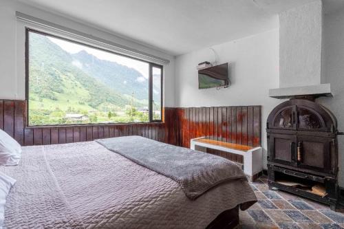 a bedroom with a bed and a large window at Hosteria Pampallacta in Papallacta