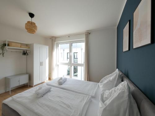 uma cama branca num quarto com uma janela em 85qm, Parkplatz, zentral, großer Balkon, 2 Bäder em Paderborn