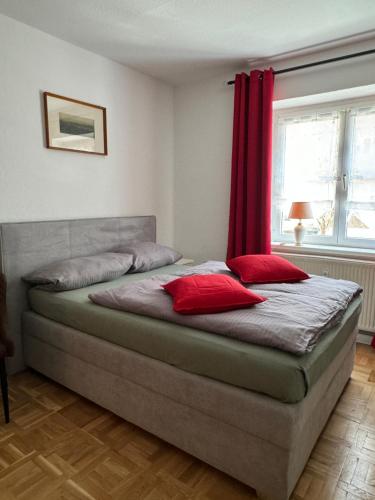 uma cama com duas almofadas vermelhas num quarto em Sweet Home Inside Dresden four em Dresden