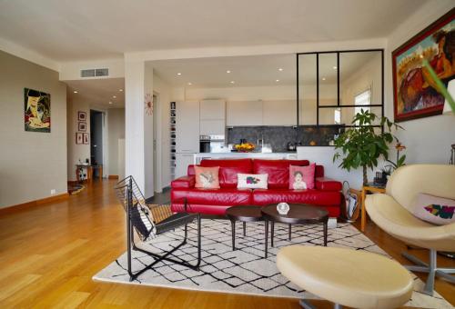 un salon avec un canapé rouge et une table dans l'établissement Appartement chic à Cannes, avec terrasse et cheminée, 83 m², à Cannes