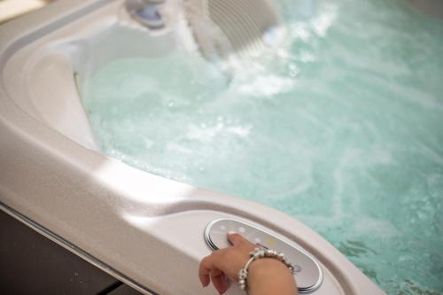 a person is reaching into a jacuzzi tub at La Vie Est Belle in Ixia