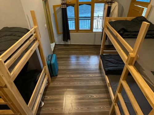 a room with two bunk beds in a room at Wabi Sabi Riverside Hostel in Kasol