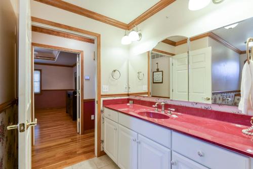 a bathroom with a red sink and a mirror at 5 Bedroom Vacation Home Next To Silver Dollar City in Branson