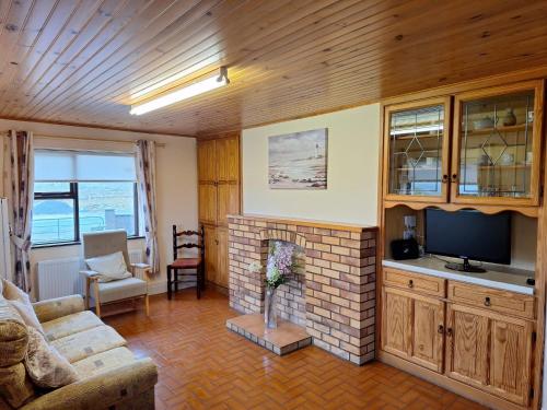 a living room with a fireplace and a television at Little Tara, Ballyconneely in Ballyconneely