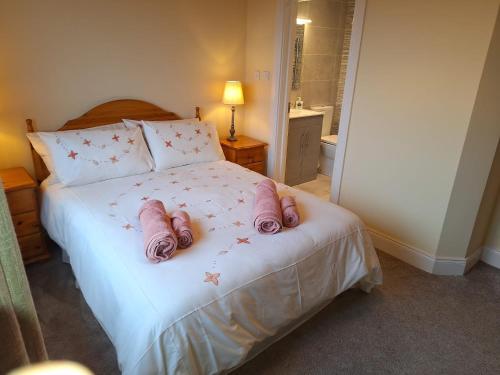 a bedroom with a bed with pink pillows at Little Tara, Ballyconneely in Ballyconneely