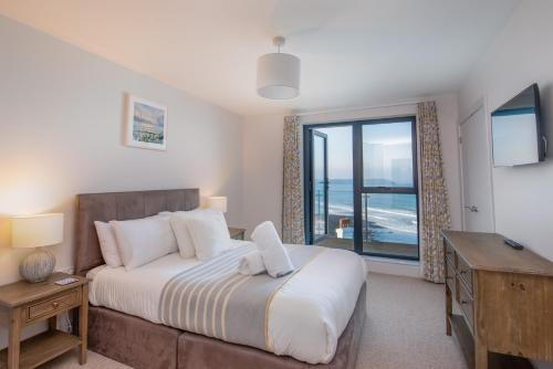 a bedroom with a bed and a view of the ocean at Rock Pool in Mortehoe
