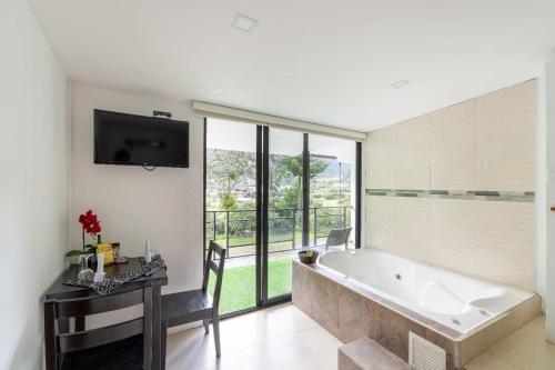 a large bathroom with a tub and a table with a desk at Hosteria Pampallacta in Papallacta