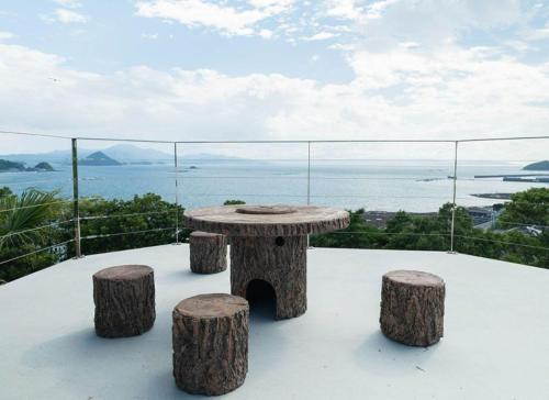 a table and stools on a balcony with a view of the ocean at LaVilla - Vacation STAY 27602v in Nobotate
