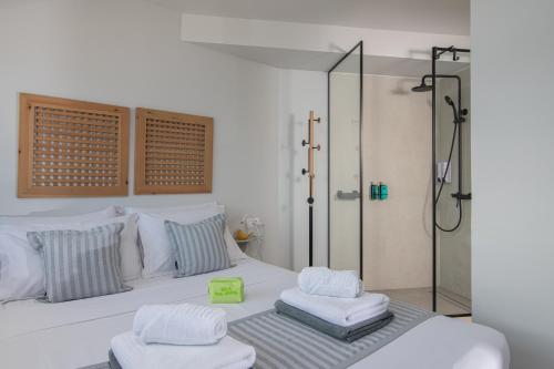 a bedroom with a shower and a bed with two towels at Beachfront Salty Sea Luxury Suite 2 in Agios Nikolaos