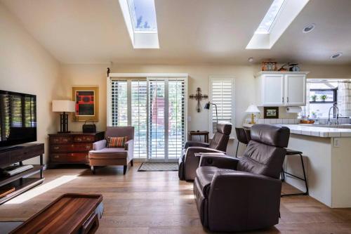 una sala de estar con sofás y una cocina con tragaluces. en Bay View Ridge Holiday Home Private Pool Hot Tub between Santa Cruz and Monterey, en Watsonville