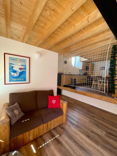 a living room with a couch and a large window at La MaiZon du Bois in Champagny-en-Vanoise