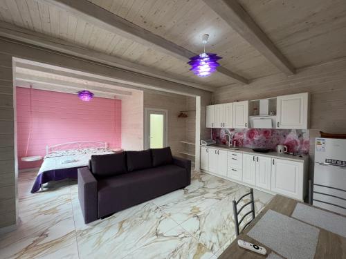 ein Wohnzimmer mit einem Sofa und einer Küche in der Unterkunft Кольорове життя in Mykulytschyn