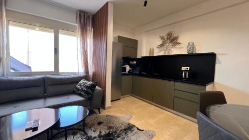 uma sala de estar com um sofá e uma televisão em Tropical Apartment em Durrës