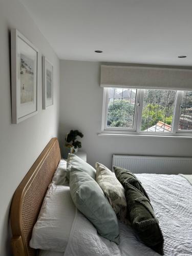 łóżko z poduszkami w sypialni w obiekcie Gorgeous 1 bedroom & private ensuite in Central Windsor home with FREE PARKING w mieście Windsor