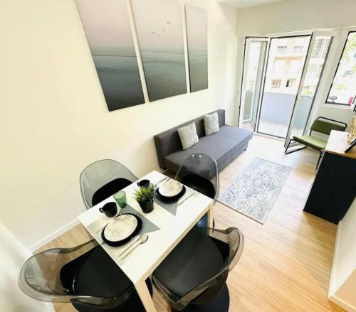 ein Wohnzimmer mit einem Tisch, Stühlen und einem Sofa in der Unterkunft Amazing Flat Perfect for Tourists in Lissabon