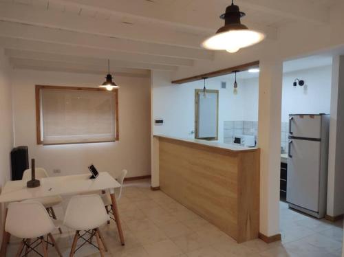 a kitchen with a table and chairs and a refrigerator at La Juliana in Villa La Angostura
