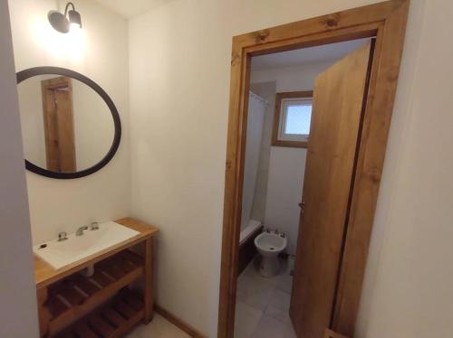 a bathroom with a sink and a mirror and a toilet at La Juliana in Villa La Angostura