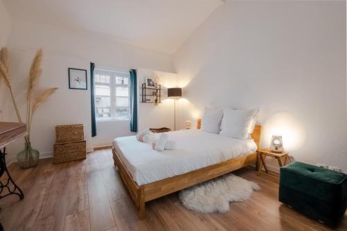 une chambre avec un lit avec des draps blancs et un tapis dans l'établissement 3 étoiles tout confort centre historique au calme entre océan, vignobles et chateaux, à Bordeaux