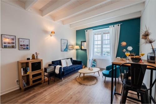 un salon avec un canapé bleu et une table dans l'établissement 3 étoiles tout confort centre historique au calme entre océan, vignobles et chateaux, à Bordeaux