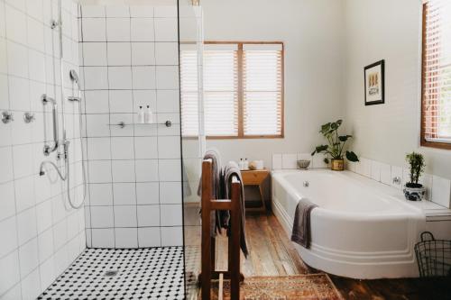 a white bathroom with a tub and a shower at The Bethesda in Nieu-Bethesda