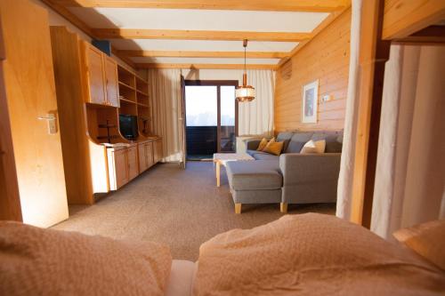 ein Wohnzimmer mit einem Sofa und einem TV in einem Zimmer in der Unterkunft Ferienwohnung Jaufenthaler Zettersfeld in Lienz