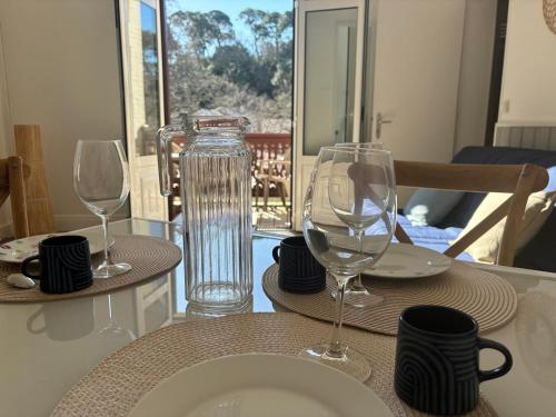 - une table avec deux verres à vin en haut dans l'établissement T2 Arcachon Vacances et Plages a 50 mètres, à Arcachon
