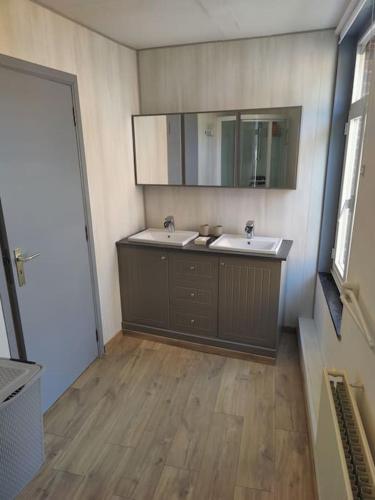 a bathroom with two sinks and a mirror at La pleine lune in Chimay