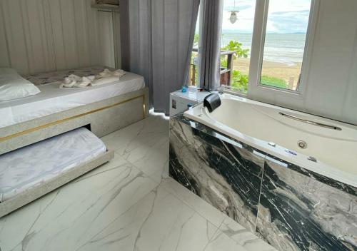 a bathroom with a tub and a bed and a window at Pousada São Miguel Beach Beira Mar in Penha