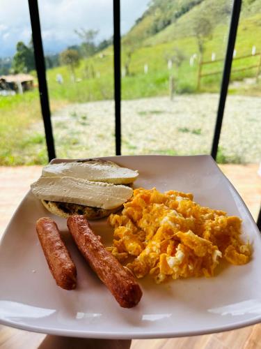 un plato de desayuno con salchichas y tostadas en Glamping Samadhi - el Peñol, en El Peñol