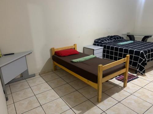 a small room with two beds and a desk at 203 verão kit exclusiva in Brasilia