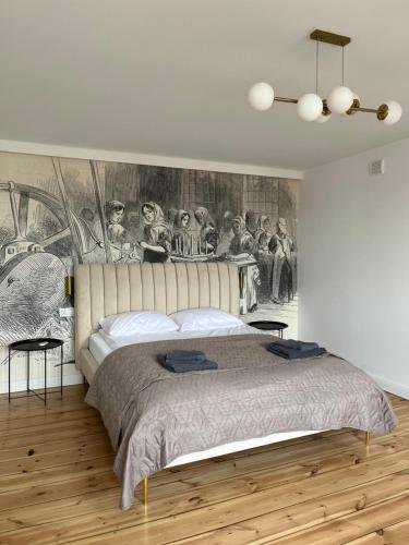 1 dormitorio con 1 cama y una pintura en la pared en Brickller Apartments by Letrent, en Żyrardów