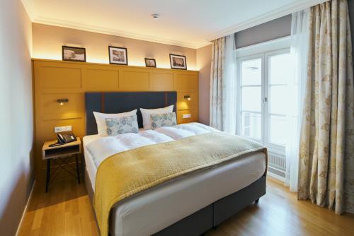 ein Schlafzimmer mit einem großen Bett und einem Fenster in der Unterkunft Boutique Hotel Orangerie in Düsseldorf