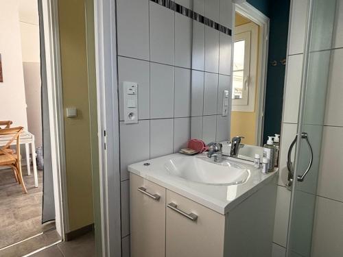 une salle de bain avec un lavabo et un miroir dans l'établissement T2 Arcachon Vacances et Plages a 50 mètres, à Arcachon