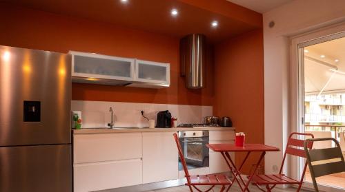 a kitchen with a stainless steel refrigerator and a table at Wanderlust Guesthouse in Gaeta