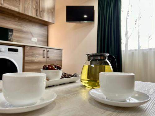 a table with two cups and a jug of oil at Byurakan Villas near Kari Lake in Byurakan