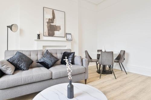 a living room with a couch and a table at Stylish 2 Bedroom Apartment in Central Cheltenham in Cheltenham