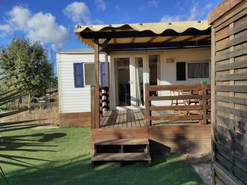 a house with a wooden deck with a pergola at Mobil-home dans un beau cadre à 15 km des plages. in Lunel