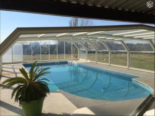 a large swimming pool in a building with a plant at Mobil-home dans un beau cadre à 15 km des plages. in Lunel