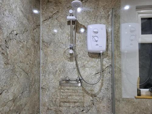 a shower in a bathroom with a glass door at White O'Morn Cabin in Newry